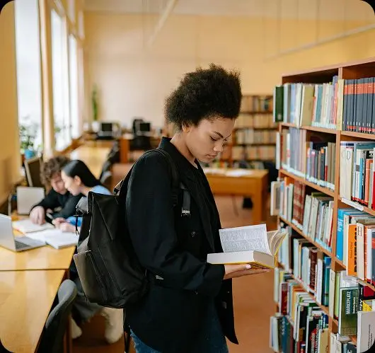 Two students studying together in a library, representing accelerated learners who advance through Teneo's curriculum at their own pace