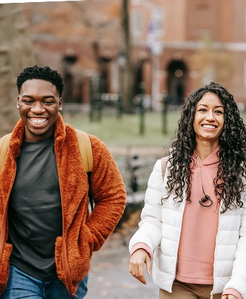 Young man and young woman walking and chatting outdoors